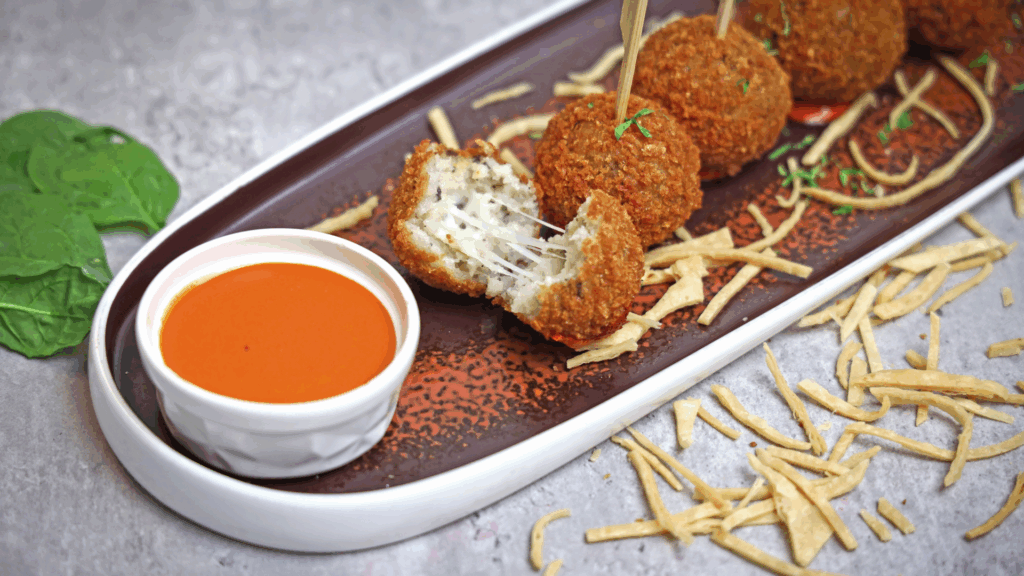 Arancini Crocantes na Air Fryer (Plant-Based) 1 Uma explosão de sabor e textura: crocantes por fora, cremosos por dentro. Esses arancini são recheados com a combinação perfeita de azeitonas verdes e pimentões picantes, envoltos em arroz Arborio temperado com alho e levedura nutricional. Tudo isso empanado em farinha panko e assado na air fryer até dourar. Uma verdadeira delícia italiana sem culpa!