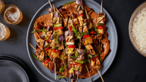 Estes espetinhos coloridos e nutritivos são ideais para quem busca uma refeição leve, rica em proteínas vegetais e cheia de sabor. O tofu extra-firme fornece proteínas de alta qualidade, enquanto os legumes variados oferecem fibras, vitaminas e minerais essenciais. O molho de amendoim com toque de limão e pimenta caiena adiciona um sabor marcante e propriedades antioxidantes.