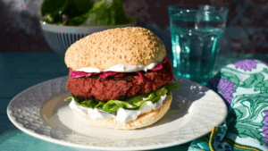Um hambúrguer plant-based nutritivo, colorido e cheio de sabor para refeições leves e funcionais Esse hambúrguer é a escolha perfeita pra quem quer fugir das versões industrializadas e trazer mais nutrientes, fibras e proteína vegetal pra rotina. A beterraba dá cor e leve adocicado, o grão-de-bico traz textura e saciedade, e a aveia ajuda a manter tudo unido — sem precisar de ovos ou farinha refinada.