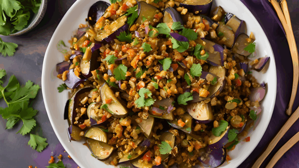 Salada Morna de Berinjela Temperada com Especiarias (Plant-Based) 1 Uma fusão de sabores etíopes em um prato funcional e reconfortante Esta salada morna combina a textura macia da berinjela com o sabor intenso do tomate e o toque picante das especiarias etíopes. Servida com pão pita integral, é uma opção perfeita para um lanche nutritivo ou acompanhamento sofisticado.